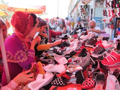 Excited shoppers at a shoe shack; Kashgar bazaar
