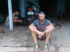 Disgruntled Robby after our motorbike suffers a flat tire. Amazingly, this honest repairman fixed it for only 10,000 Kip (about $1.20)