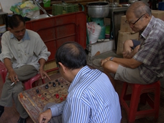 Thai men engrossed in their afternoon board game