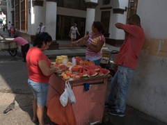 A fruit vendor conducting brisk business