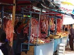 A wide variety of freshly butchered meat; outdoor market