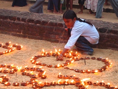 Young girl lighting candles at Gal Vihare in preparation for Vesak festival