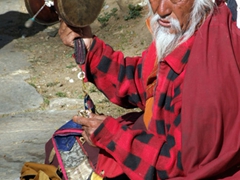 Beating his damaru (a hand held two-headed drum)