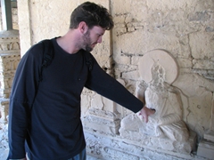 Robby sticking his finger in a well-worn hole in a Buddha statue (supposedly for good luck!)