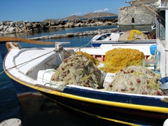 A fishing boat laden with nets pulls into harbor; Naoussa