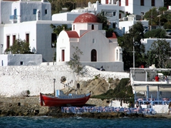 A pretty red roofed church stands out in whitewashed Hora
