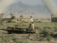 This photo was taken by "DKET Bob", who peered outside the camp's fence to snap this portrait of an elderly man sitting atop an old tank; Bagram