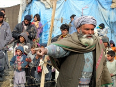 A village elder directs traffic at the refugee camp distribution