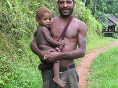 A proud father holding his child;  Yimas Lake region