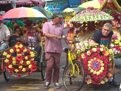 Flower bedecked rickshaws provide a colorful view of touristy Malacca