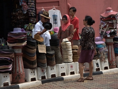 Anh Hai and Ann haggle the final price of a souvenir hat; Malacca