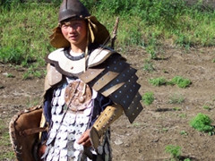 A boy dressed in Genghis Khan attire flaunts his stuff outside of Erdene Zuu monastery