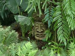 Carved faces at the base of trees are seen at Jurong Bird Park
