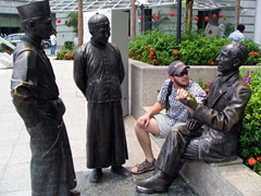 Robby jumps in this bronze scene of "The River Merchants", depicting a prominent merchant of the early days, Scottish Alexandre Laurie Johnston, negotiating with a Chinese trader and a Malay chief