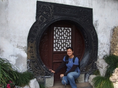 Becky crouches down next to a circular doorway