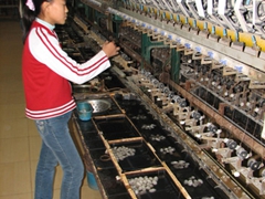 A worker spins silk thread; Kaldi Silk Factory