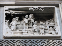 Extreme close up view of a door panel scene carved over the entranceway; Garden of the Master of the Nets