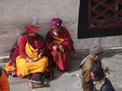 Two nuns huddle and gossip; Barkhor District