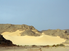 Sand dunes encroach upon the existing rocky outcrops; Tilalen
