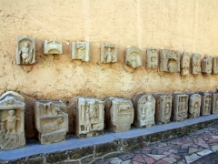 Grave stone markers lining the wall outside Timgad's museum
