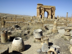 Cisterns used to grind olives or grains (with Trajan's Arch in the background); Timgad
