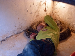 Young Algerian boy fearlessly lying down on an anaconda; Setif zoo
