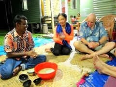 Subas hands out bowls of kava for the family to try