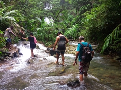 Michael (our guide) helping Tanya up to the waterfall. Notice her husband John walking barefoot behind her!