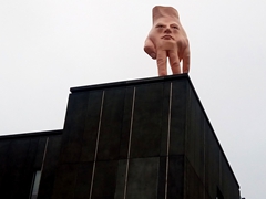 Sculpture of artist Ronnie Van Hout's hand and facial features on the roof of the Christchurch City Art Gallery