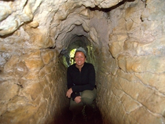 Becky crawling through a walkway at Ruakuri Cave