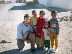 Robby posing with several children of the adobe beehive village we visited