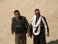 An armed security personnel walks alongside Ali, our tour guide
