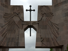 A King and Priest reach out to a cross; monument at Holy Echmiadzin