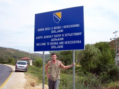 Robby under a "Welcome to Bosnia" signpost