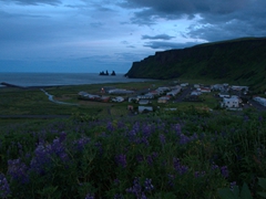 Midnight view of Vík (with Reynisdrangar pinnacles in the background)