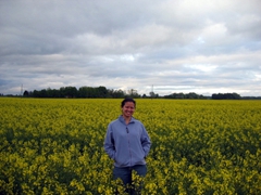 Becky standing in the middle of a rape field, Lithuanian countryside